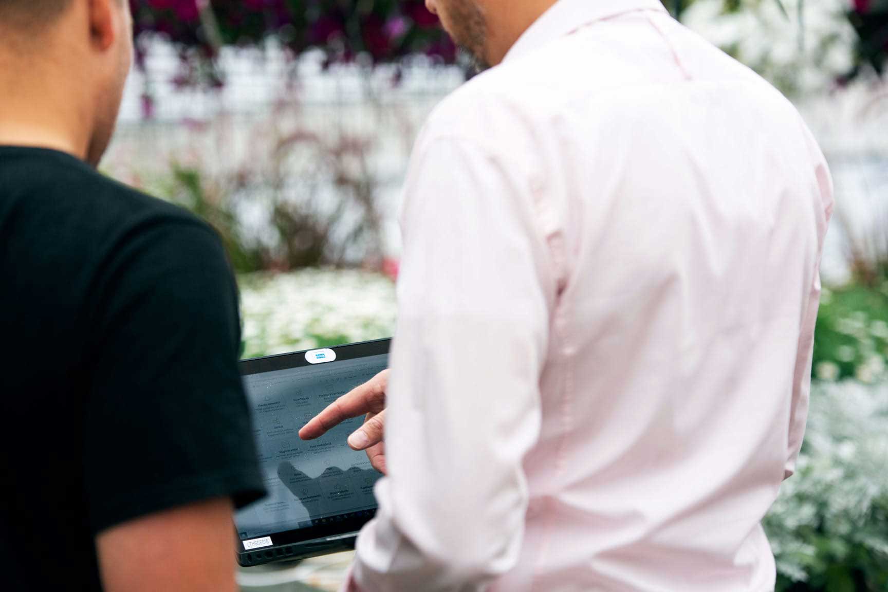 Holding computer showing demo of software