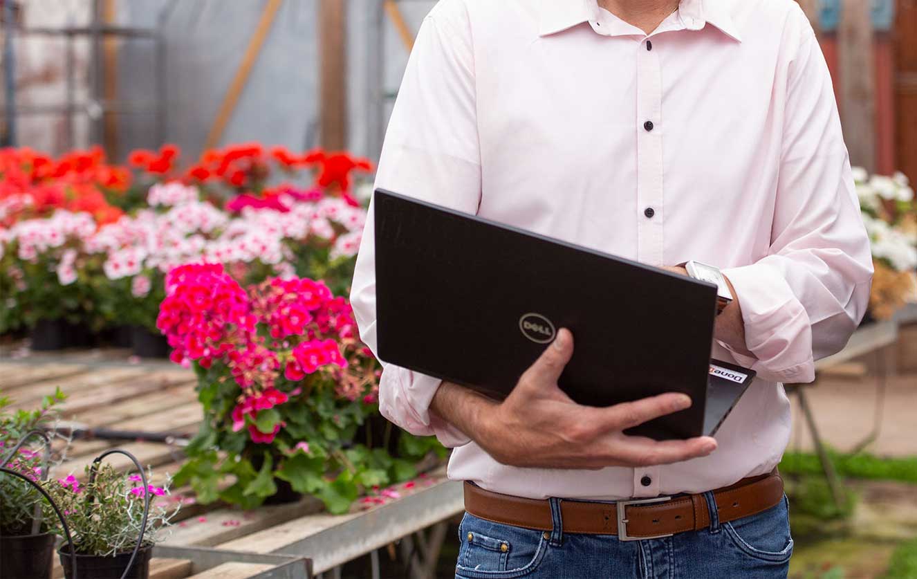 Holding computer showing demo of software